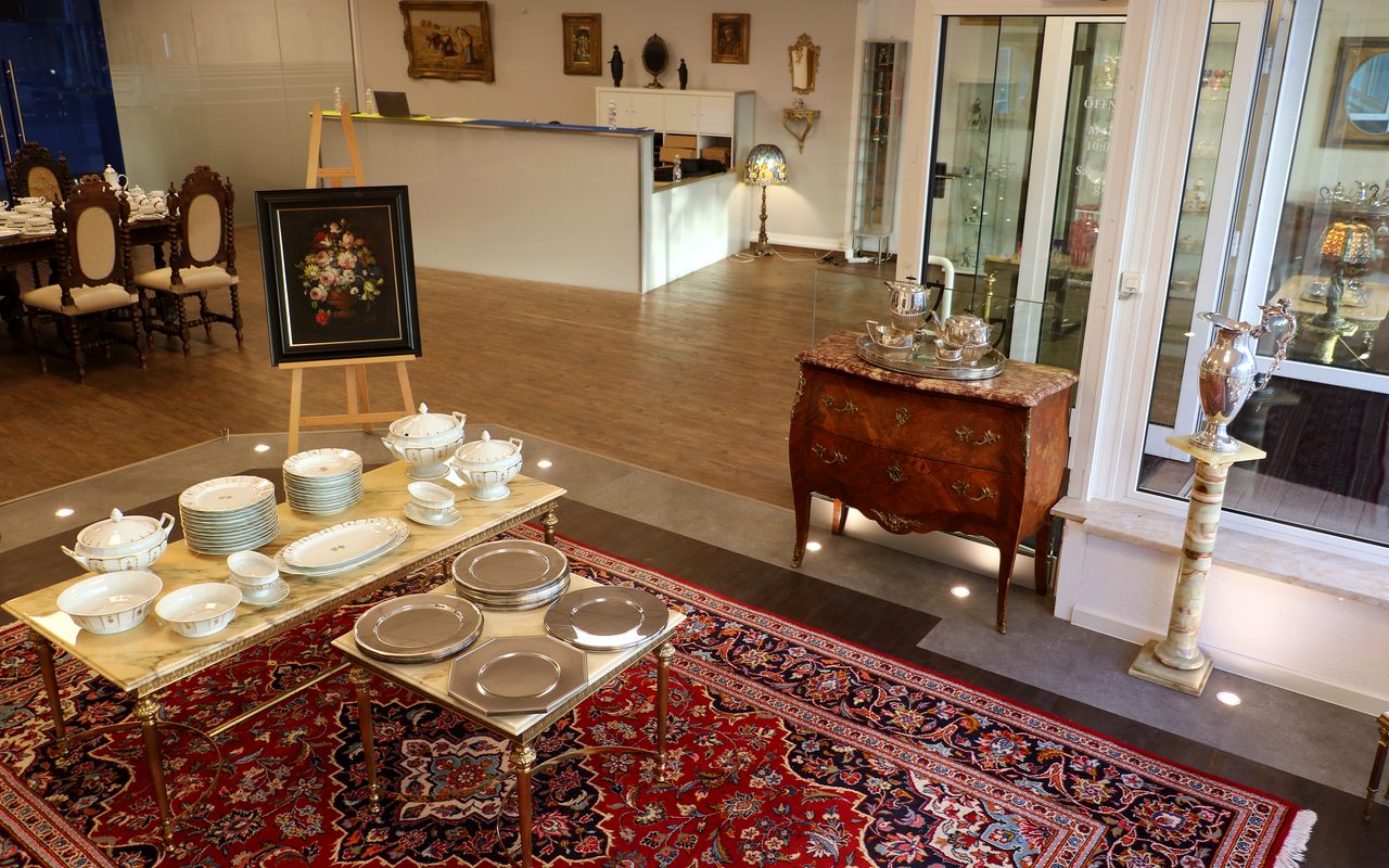 Showroom des Lilienthaler Antiquitätenhandels mit antiker Barock-Kommode, komplettem Porzellan-Service und einem Gemälde auf der Staffelei
